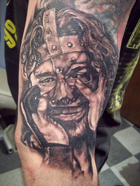 Black Ink Wrestler Face Tattoo On Half Sleeve