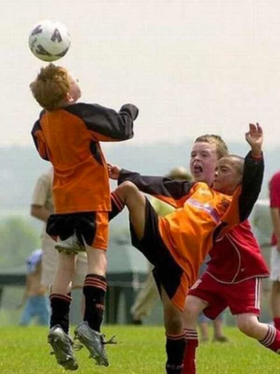 Kids Kicking Football Funny Shot Image