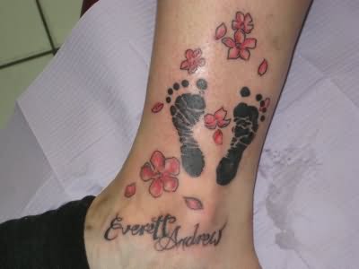 Black Footprints With Flowers Tattoo On Leg