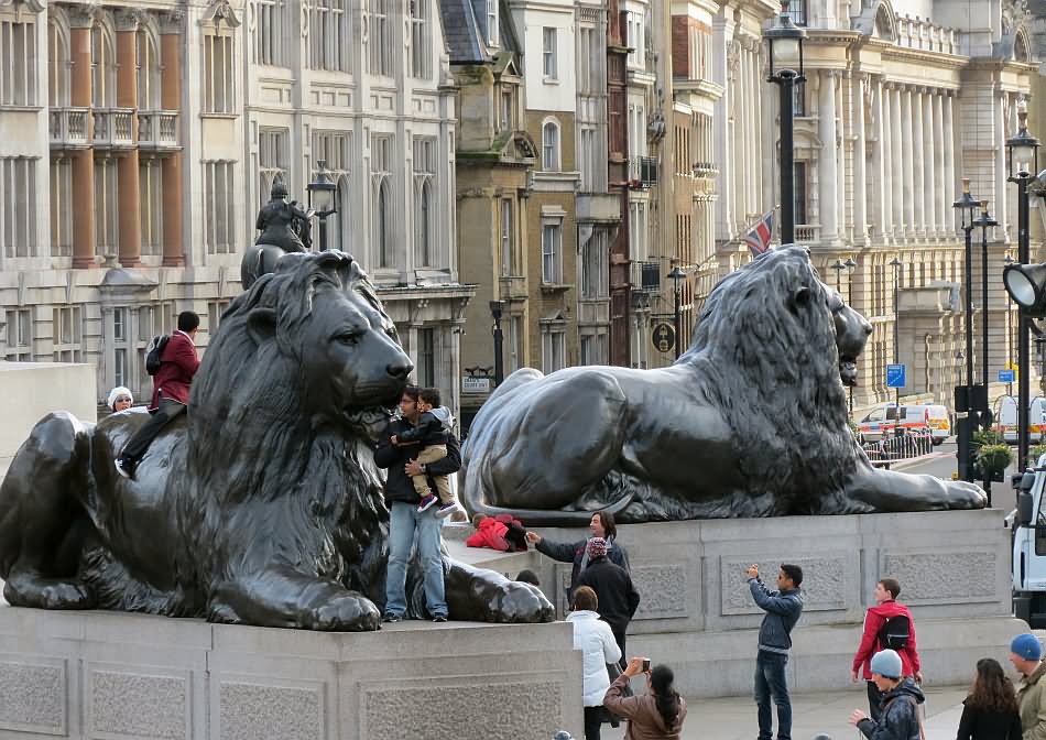 Tourists Posing For Photograph With Landseer Lion At The Trafalgar Square