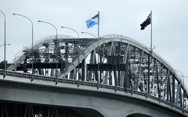 The New Zealand Flag Flies Alongside Auckland Harbour Bridge