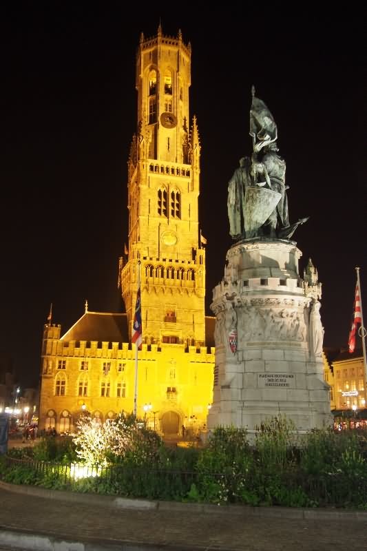 Beautiful Statue In Front Of The Belfry Of Bruges At Night