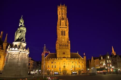 Statue And Belfry In Grote Market Lit Up At Night