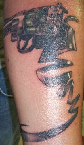 Grey Ink Ribbon And Revolver Tattoo On Sleeve