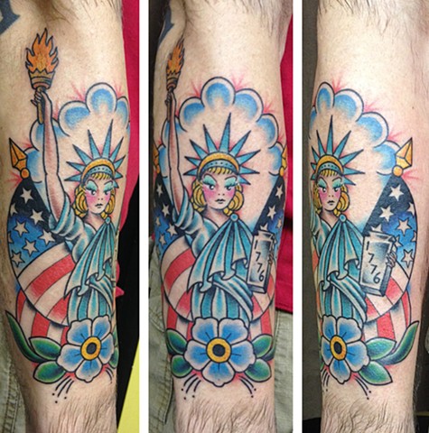 Traditional Statue Of Liberty Girl With USA Flags And Flower Tattoo Design For Arm