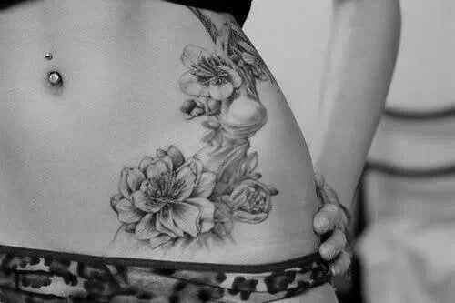 Black And Grey Flowers Tattoo On Girl Left Hip