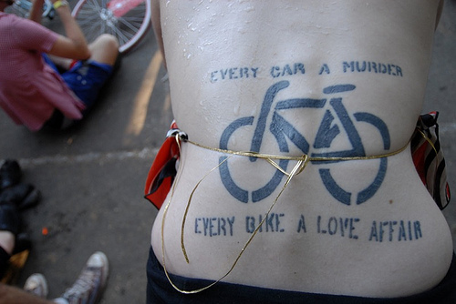 Silhouette Of Cycle With Lettering Tattoo On Lower Back