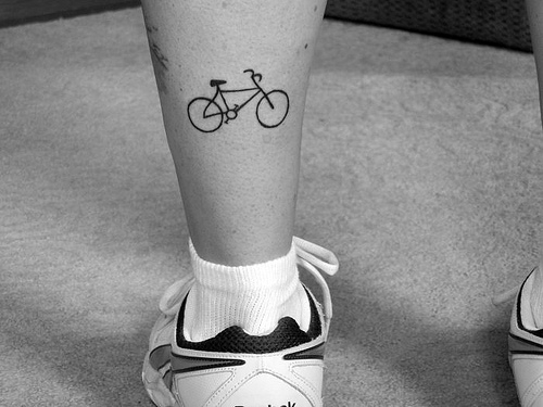 Small Black Color Cycle Tattoo On Back Leg