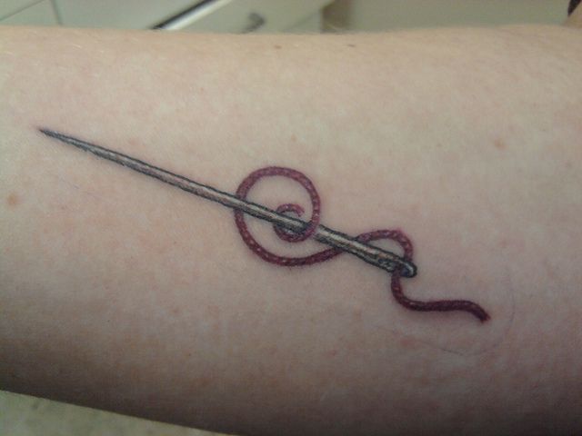 Thread And Needle Tattoo On Arm