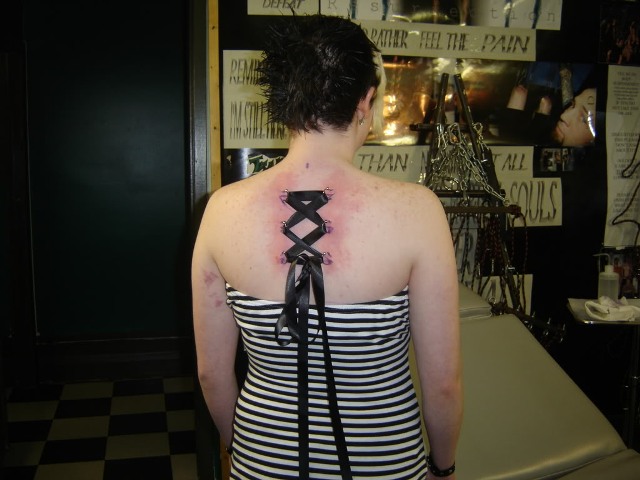 Corset Piercing On Upper Back With Black Ribbon