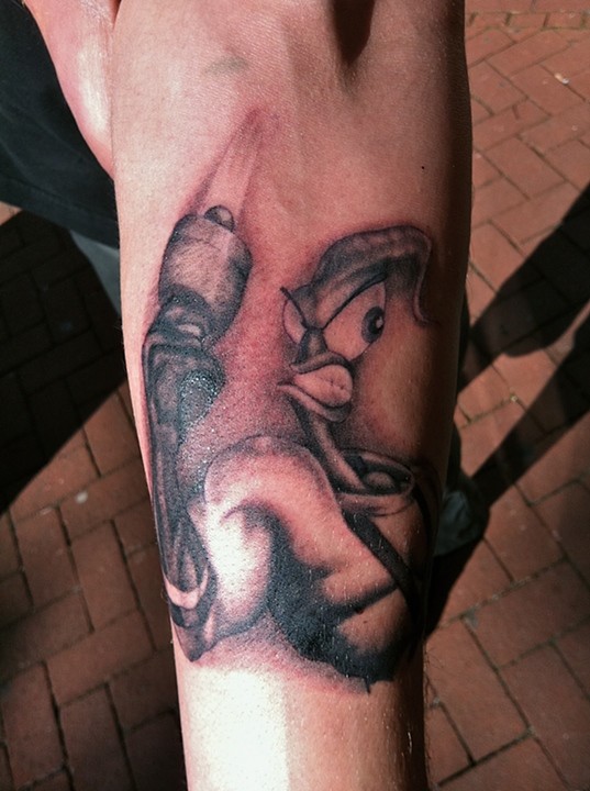 Grey And Black Angry Earthworm Jim Holding Gun Tattoo