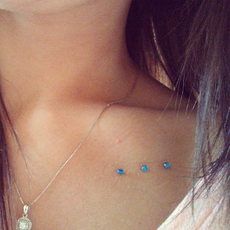 Front Shoulder Piercing With Blue Dermals