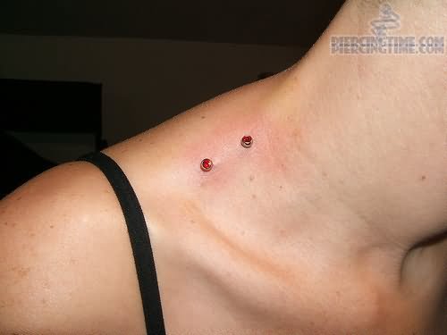 Shoulder Piercing With Red Dermals