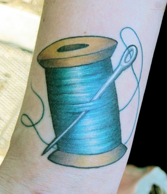 Blue Thread Spool Tattoo On Arm