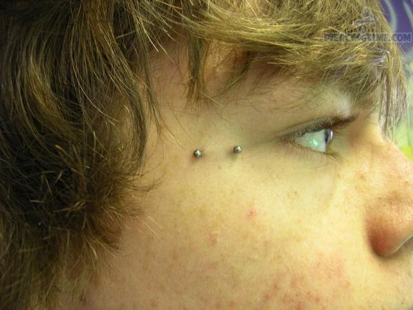 Crow Feet Piercing With Silver Barbell