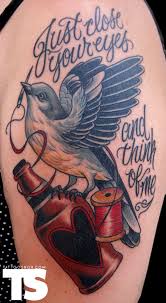 Flying Bird With Spool And Lettering Tattoo On Left Half Sleeve