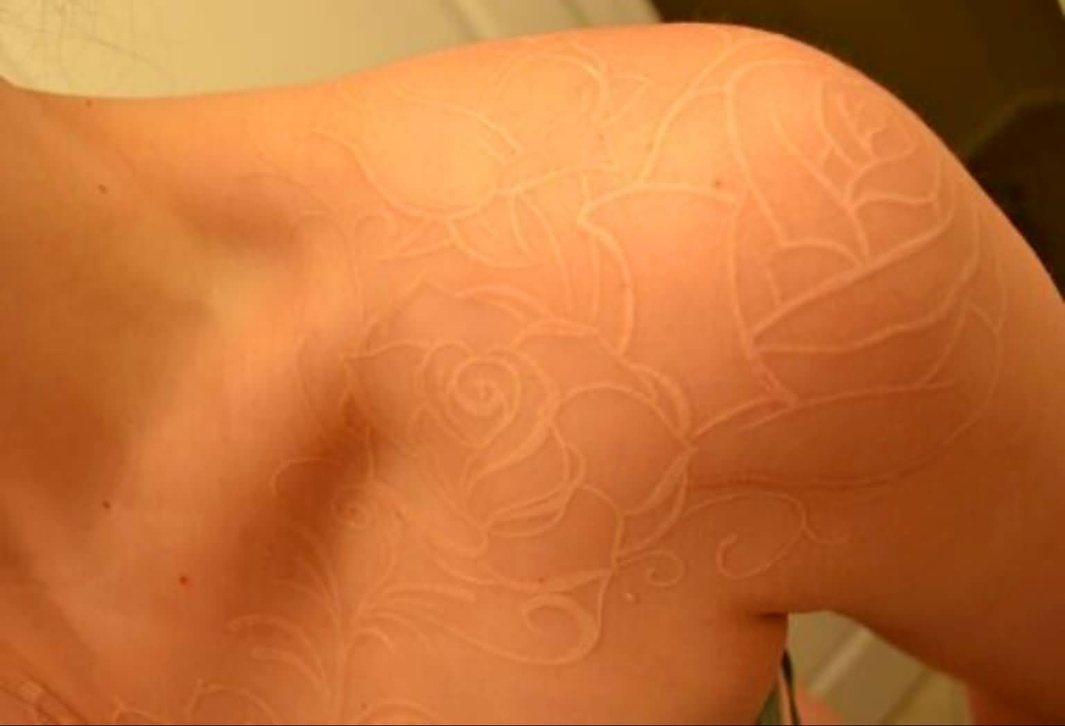 Impressive White Flowers Scarification Tattoo On Shoulder