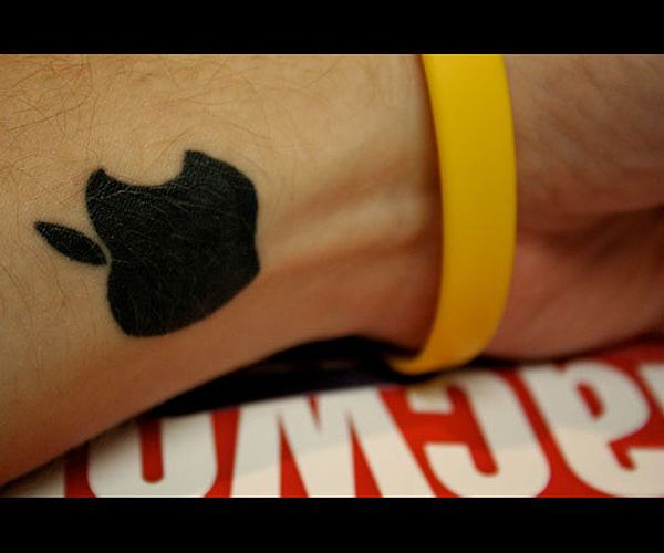 Small Black Ink Apple Logo Silhouette Tattoo On Wrist