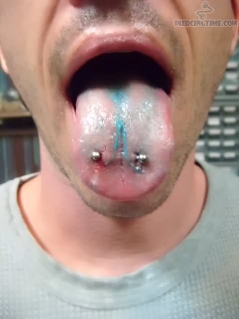 Guy Showing His Scoop Tongue Piercing With Silver Barbell