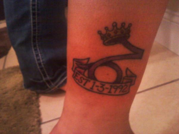 Memorial Black Ink Crown On Capricorn Zodiac Sign With Banner Tattoo Design