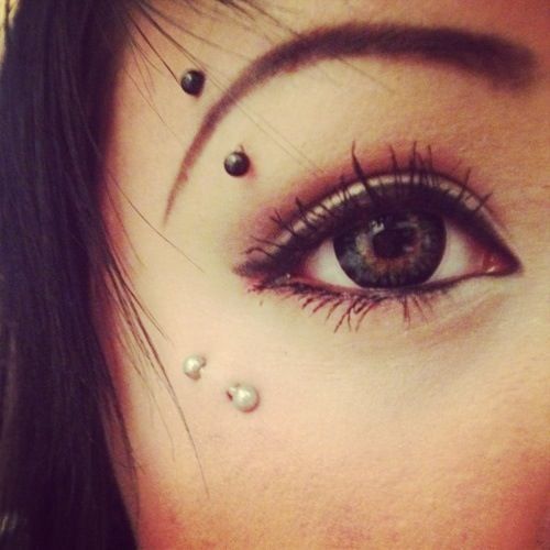 Eyebrow And Anti Eyebrow Piercing With White And Black Barbells