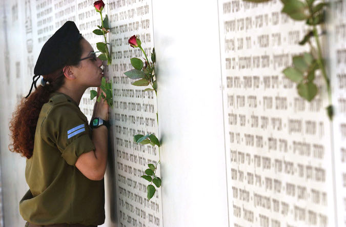 A Young Israeli Soldier Places a Rose Amongst The Names Of Those Soldiers Who Have Fallen For The Israel, On The Memorial Day Ceremony Yom Hazikaron