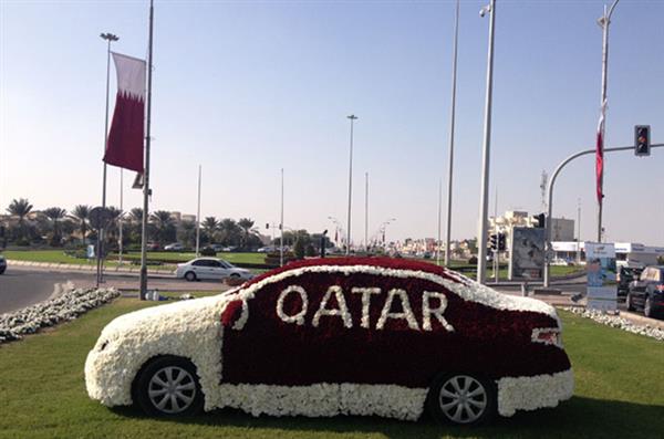 A Car Covered With Red And White Flowers And Qatar Lettering Happy Qatar National Day