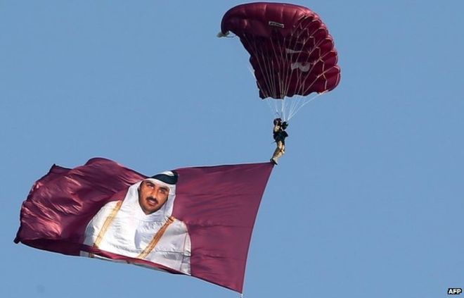 A Paraglider Pulls A Flag Showing Sheikh Tamim Bin Hamad Al Thani On Qatar’s National Day