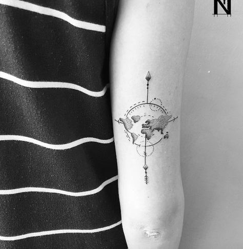 Black globe and compass directions tattoo on inner arm