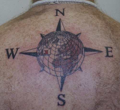 Black globe and compass tattoo with directions on upper mid back