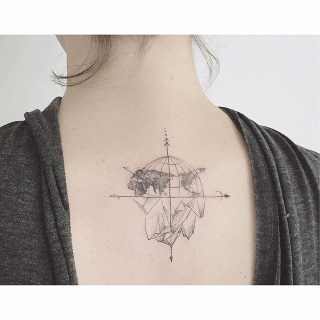 Black half globe and compass directions tattoo on upper mid back for women