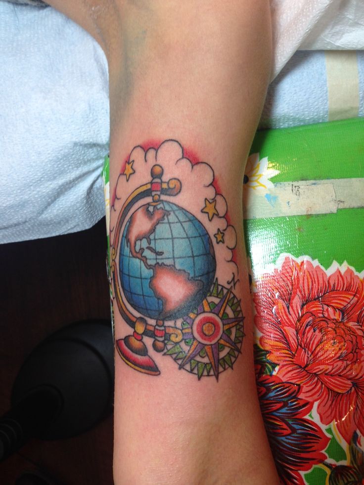 Colorful globe and compass tattoo design on arm