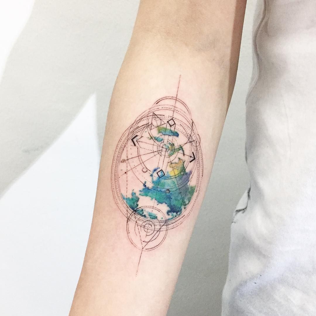 Colourful globe and compass tattoo on inner arm