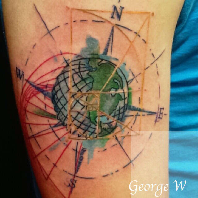 Colorful watercolor globe and compass tattoo on arm by George W