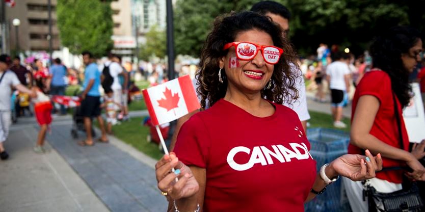 Canadian woman pose with flag during Canada day parade