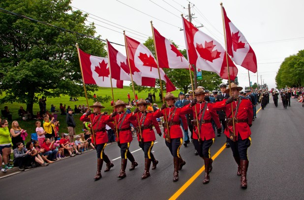 army men carrying canadian flags during Canada day parade