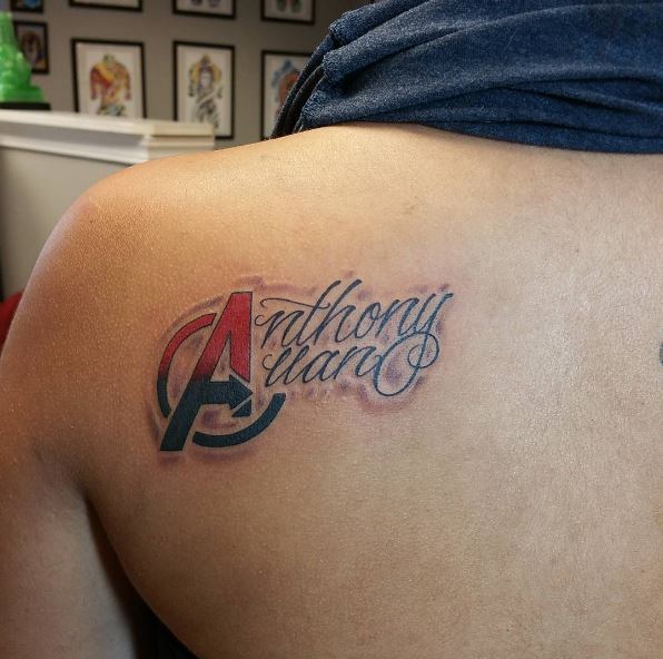 Blue and red A logo avengers tattoo on upper left back