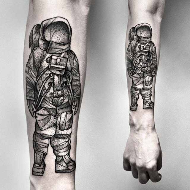 Black and grey shaded astronaut tattoo on forearm