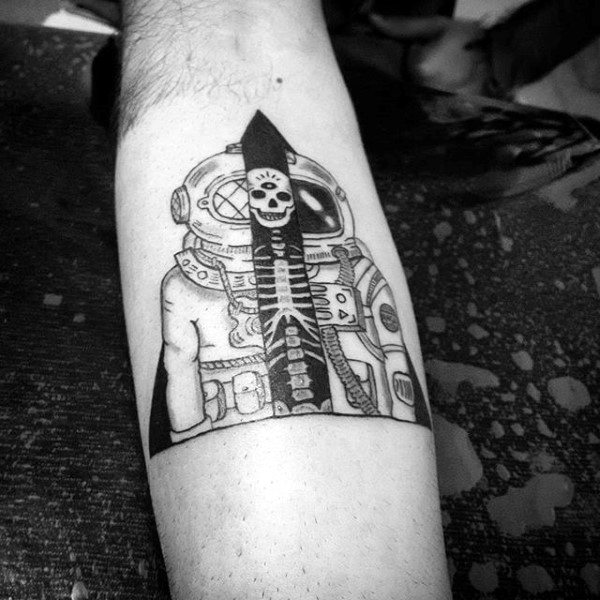 Black and grey shaded astronaut with skull tattoo on inner arm