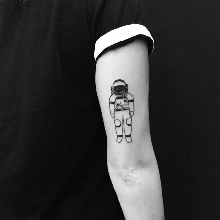 Black astronaut tattoo above elbow for men