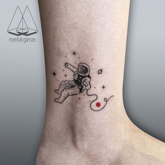 Black astronaut tattoo on ankle