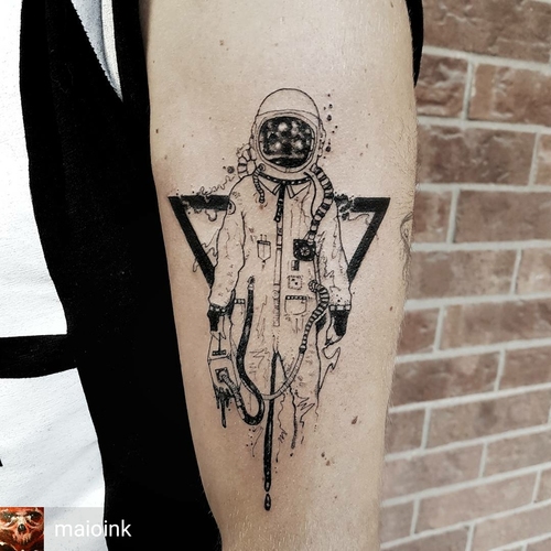 Black astronaut tattoo on arm