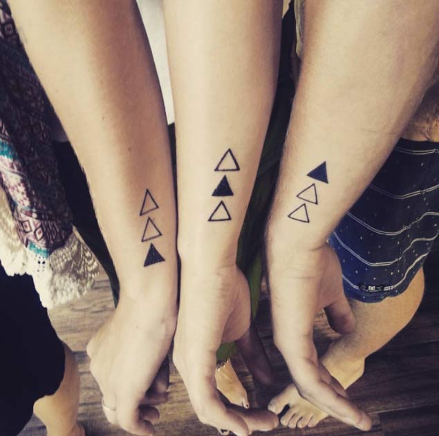 Black geometric shapes sibling tattoo above left wrist