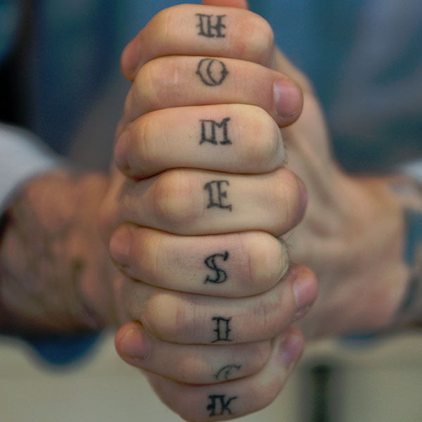 Black home sick texted knuckle tattoo