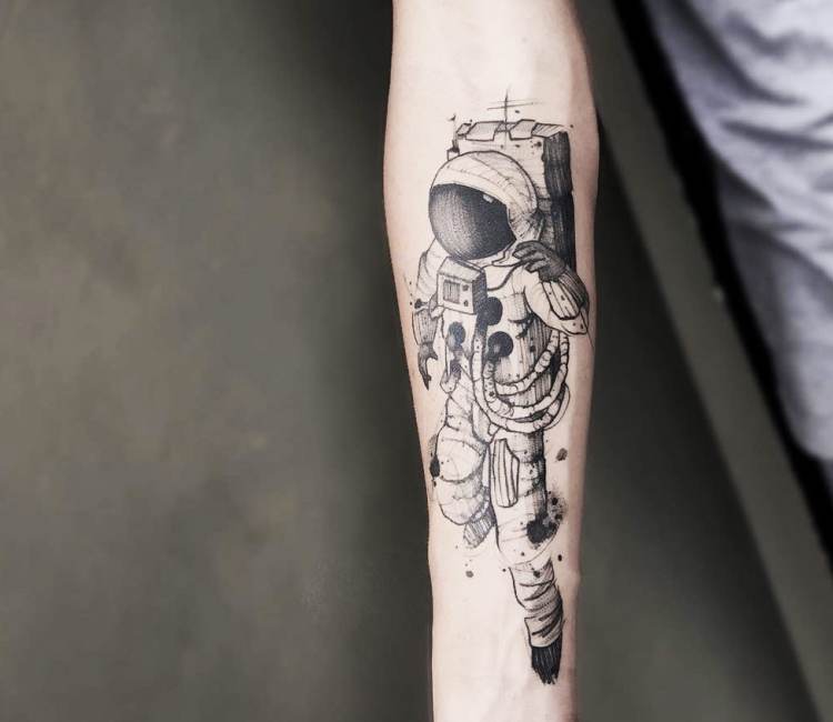 Black shaded astronaut tattoo on inner forearm