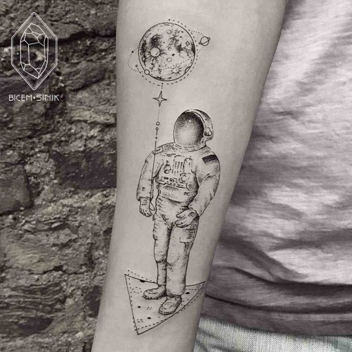 Black shaded astronaut with planets balloon tattoo on inner lower sleeve