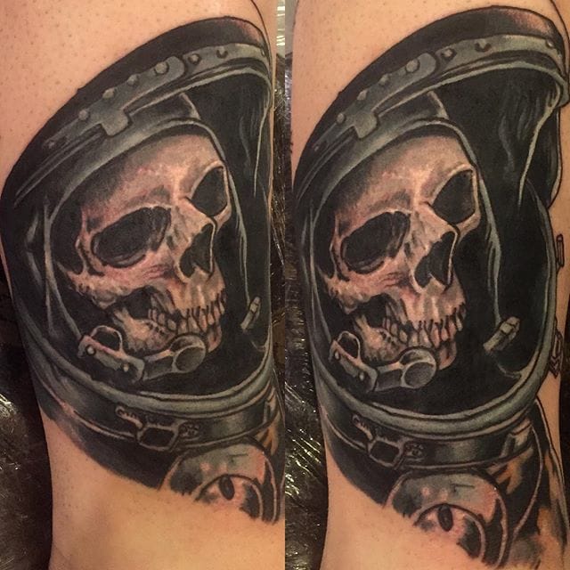 Black shaded astronaut with skull tattoo on upper forearm by Drew ONeill