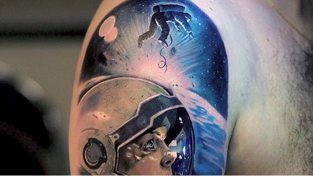 Colored astronaut tattoo on upper arm