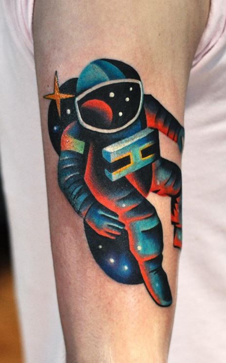 Colored astronaut tattoo on upper sleeve