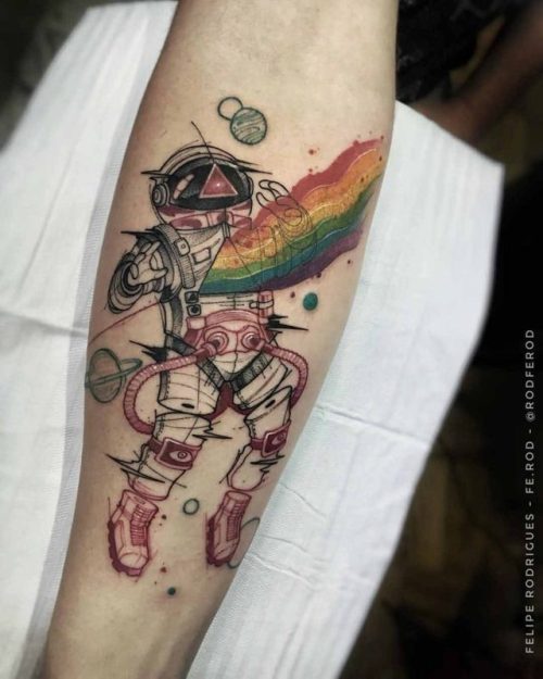 Colored astronaut with rainbow and planets tattoo on inner forearm